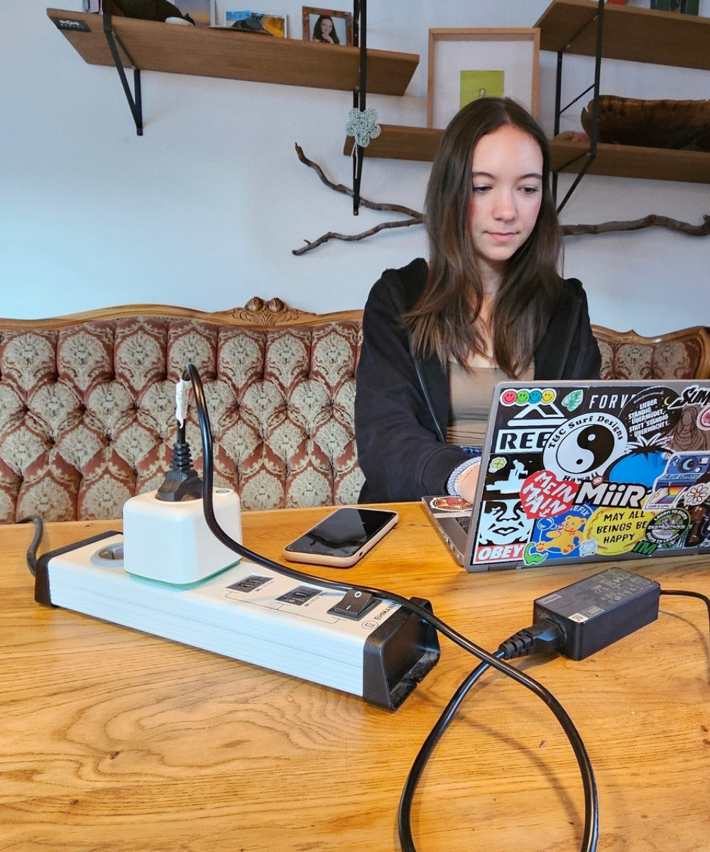 Kundin lädt Laptop mit dem Akku Life Guard am Schreibtisch – für Schule, Social Media und Streaming