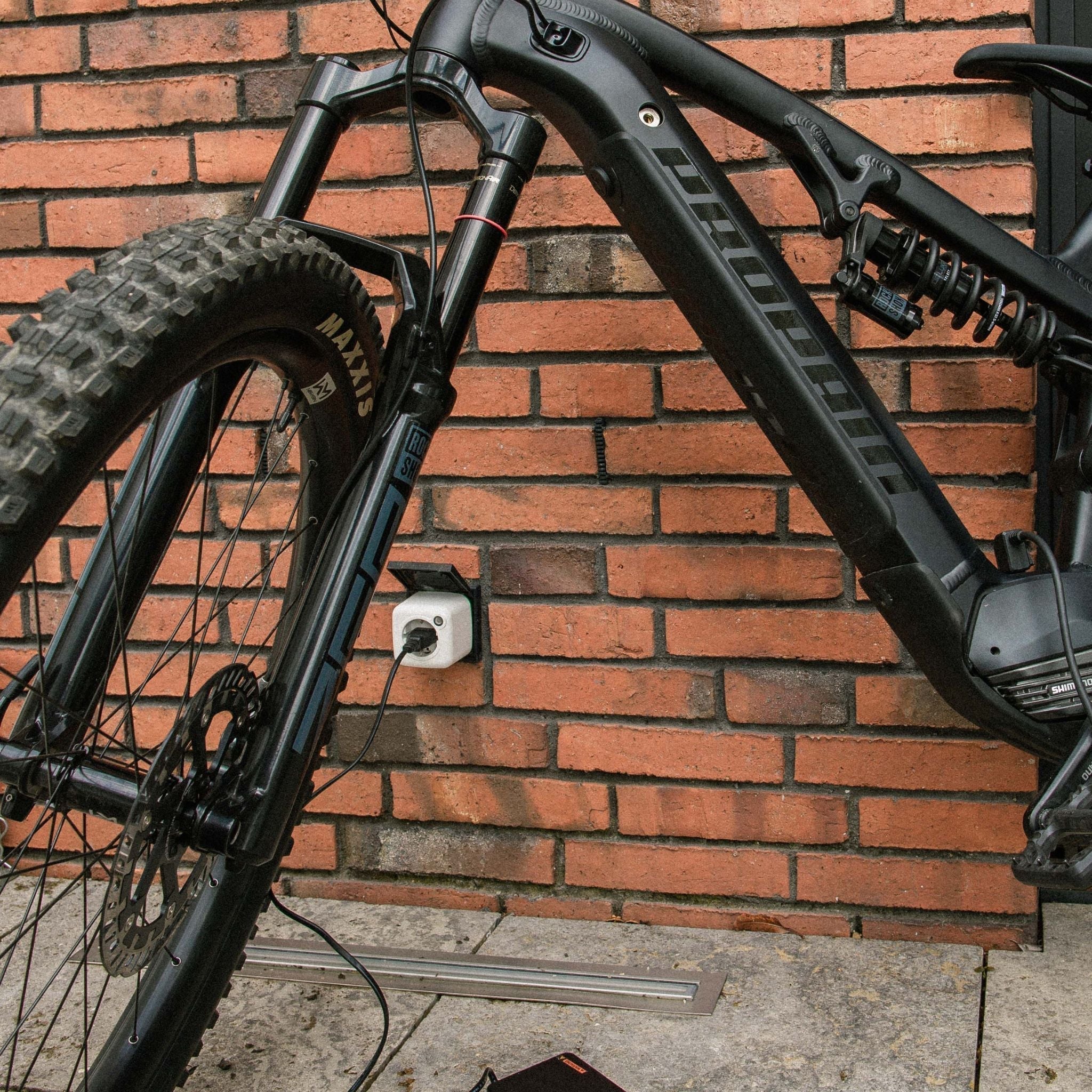 E-Bike ist zur sicheren Ladung in einen Akku Life Guard eingesteckt